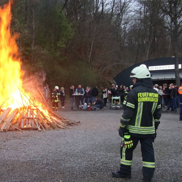 Ein Feuerwehrmann beaufsichtigt ein Osterfeuer.
