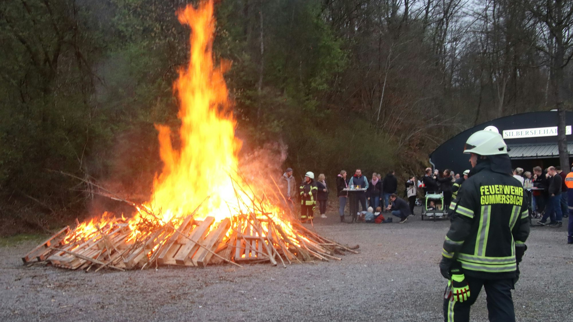 Ein Feuerwehrmann beaufsichtigt ein Osterfeuer.