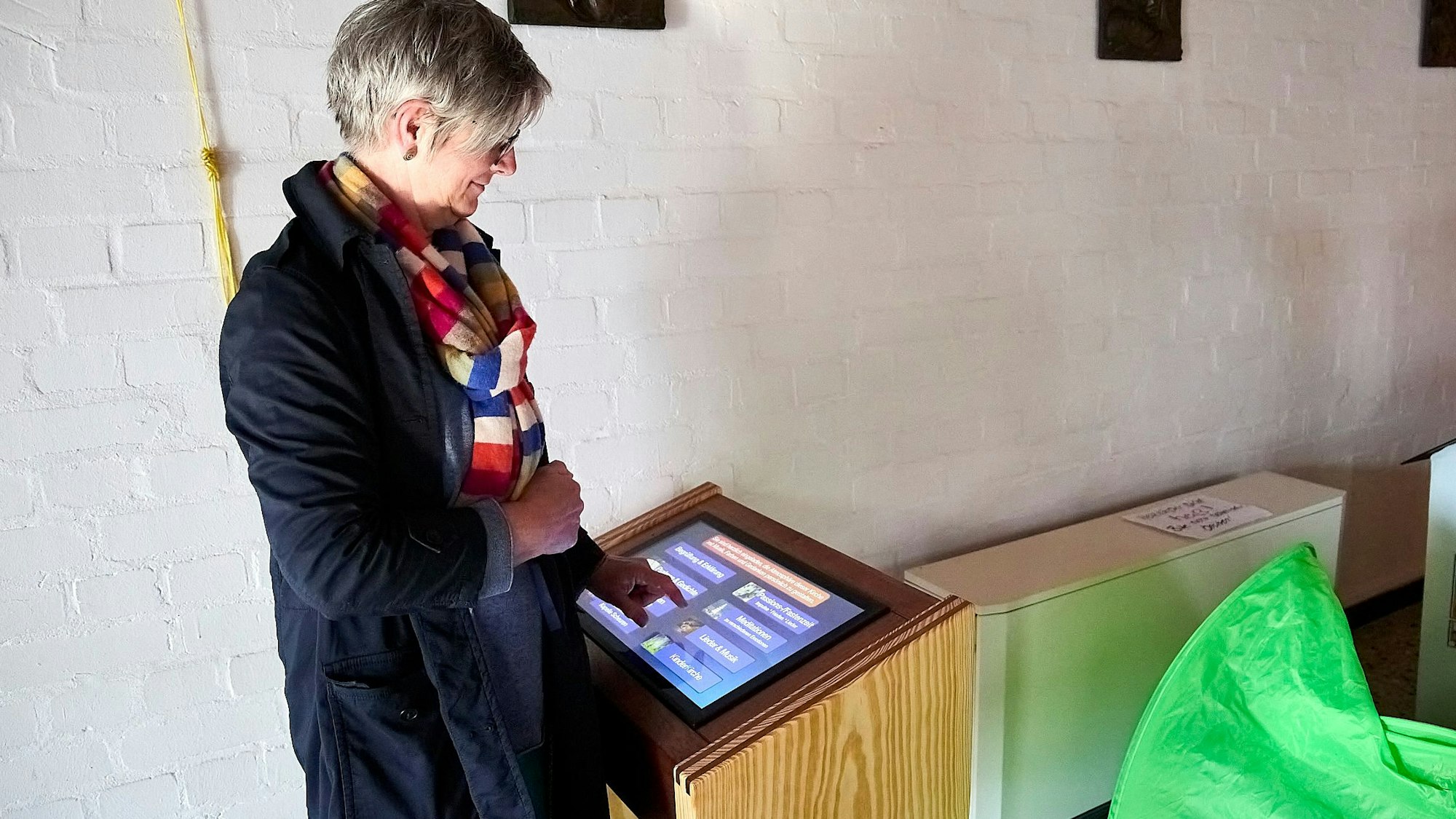 Eine Frau steht an einem Pult, in dem ein Computerbildschirm eingelassen ist.