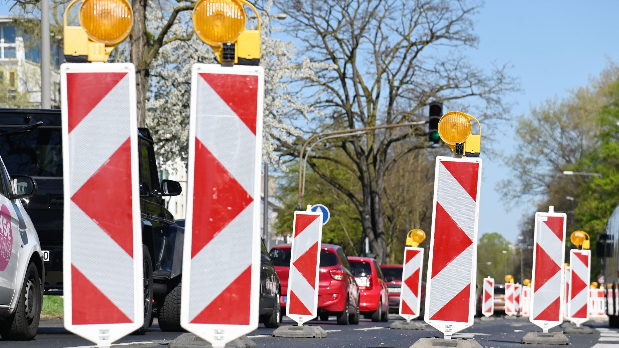 Viele Absperrbaken stehen auf einer Straße, Autos fahren gedrängt auf einer Spur.