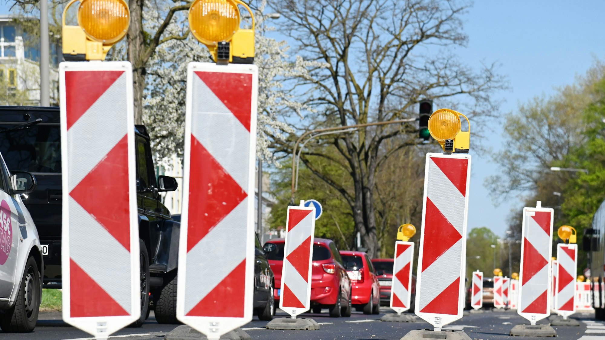 Viele Absperrbaken stehen auf einer Straße, Autos fahren gedrängt auf einer Spur.