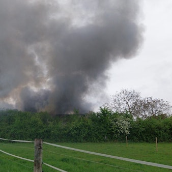 In Niederkassel-Mondorf brennt eine Halle, eine dichte Rauchsäule steht über Niederkassel.