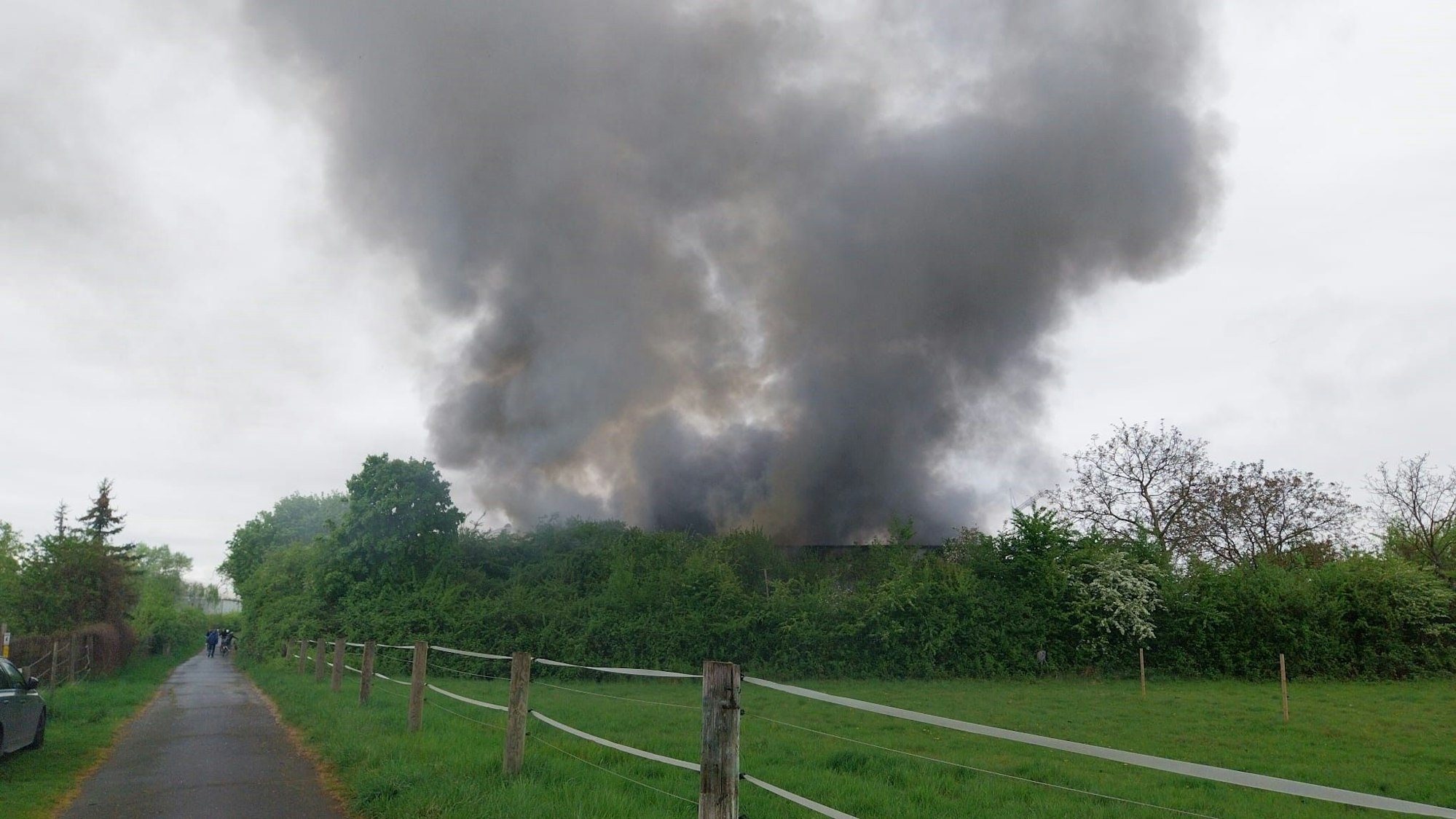 In Niederkassel-Mondorf brennt eine Halle, eine dichte Rauchsäule steht über Niederkassel.