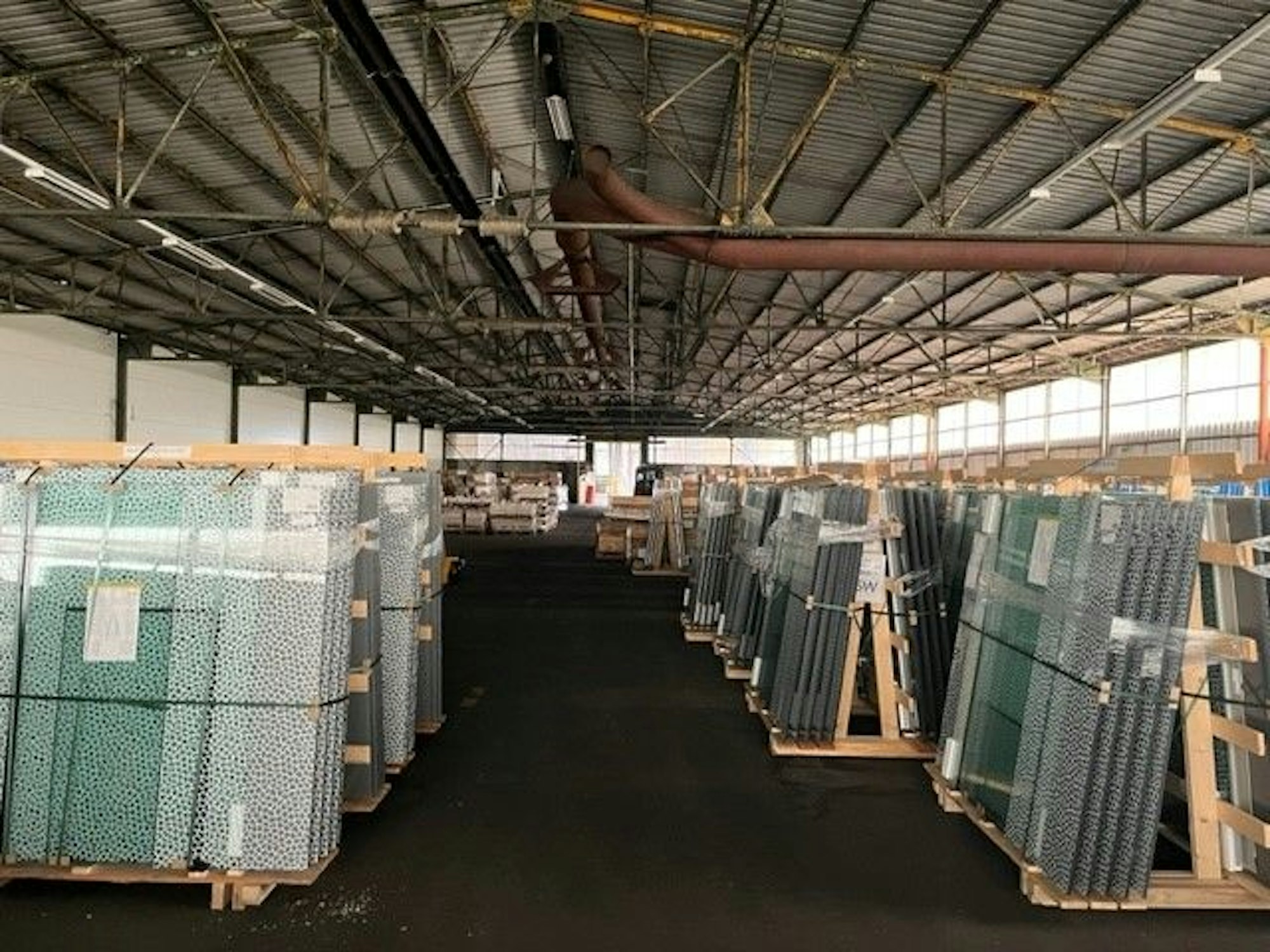 Die neuen Balkonbrüstungen lagern in einer Halle.