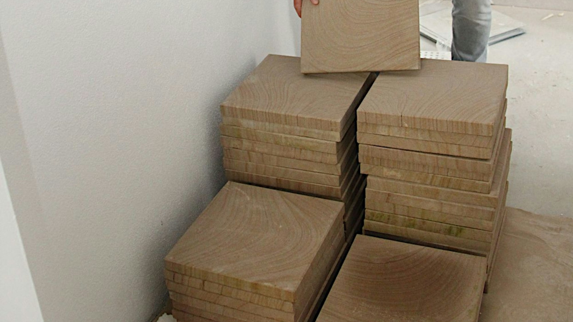 Sandsteinplatten aus dem Kylltal sind aufgestapelt. Sie werden auf dem Boden im Erdgeschoss des neuen Rathauses von Blankenheim verlegt.