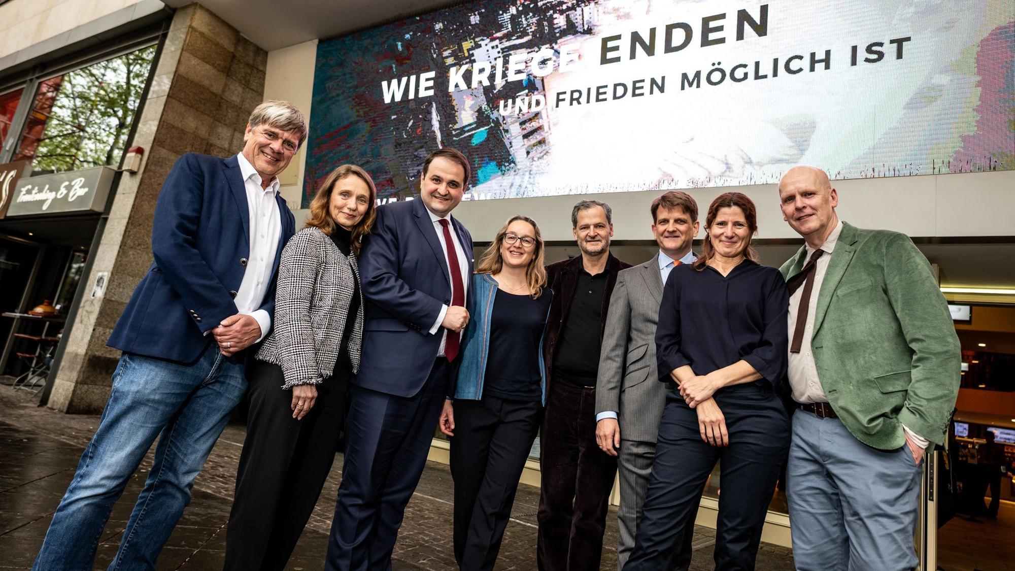 Das Team von „Wie Kriege enden und Frieden möglich ist“ mit NRW-Medienminister Nathanael Liminski (3.v.l.) vor dem Kino