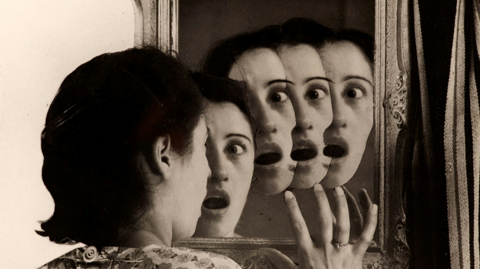 Eine Frau sieht mehrere Gesichter im Spiegel.