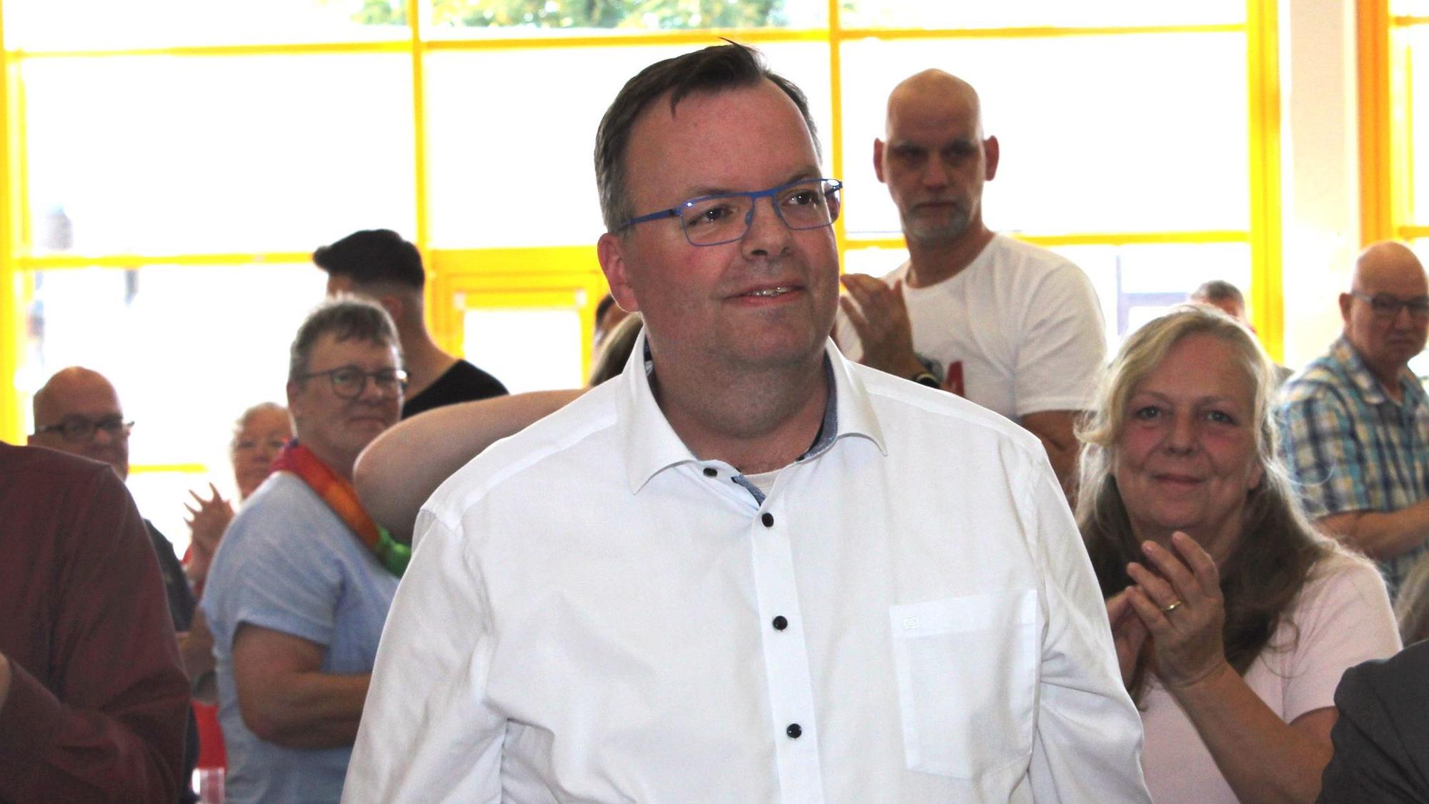 Ein Mann in einem weißen Oberhemd ist auf dem Foto zu sehen.