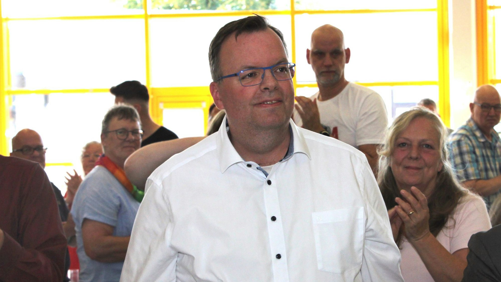 Ein Mann in einem weißen Oberhemd ist auf dem Foto zu sehen.