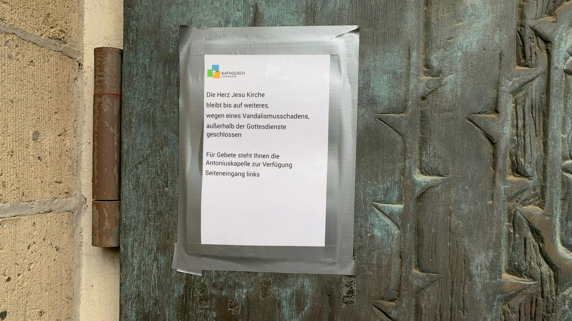 An der Kirchentür klebt ein Hinweis darauf, dass die Kirche nur noch zu Gottesdienstzeiten geöffnet ist.