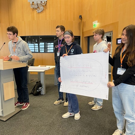 Schüler im Ratssaal mit Plakat