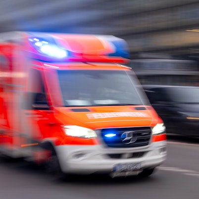 Ein Rettungswagen fährt durch die Stadt, das Bild ist leicht verschwommen.