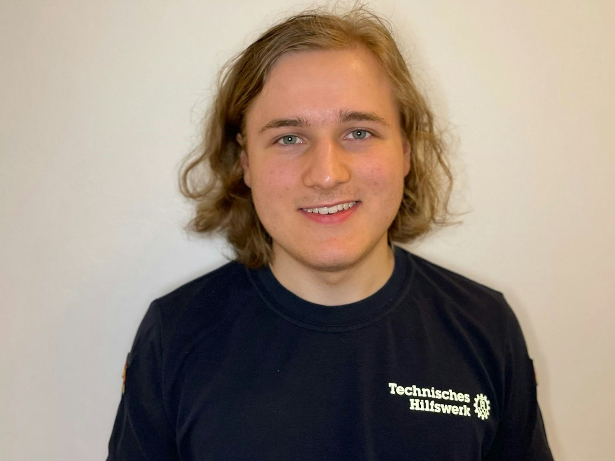 Severin Müller-Hartmann trägt ein Shirt vom THW und guckt in die Kamera.