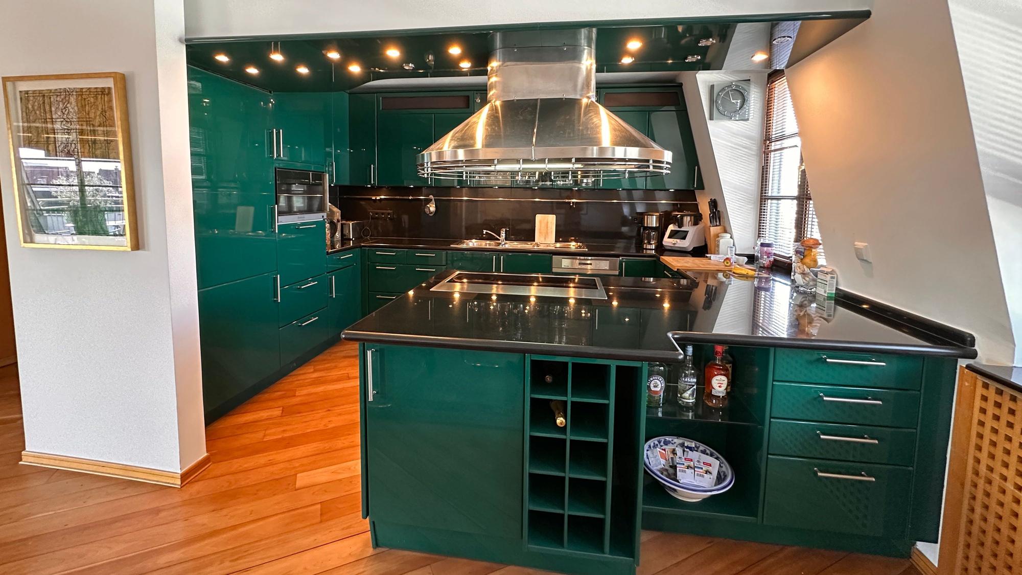 Eine dunkelgrüne Miele Siematic-Küche mit Edelstahlelementen.