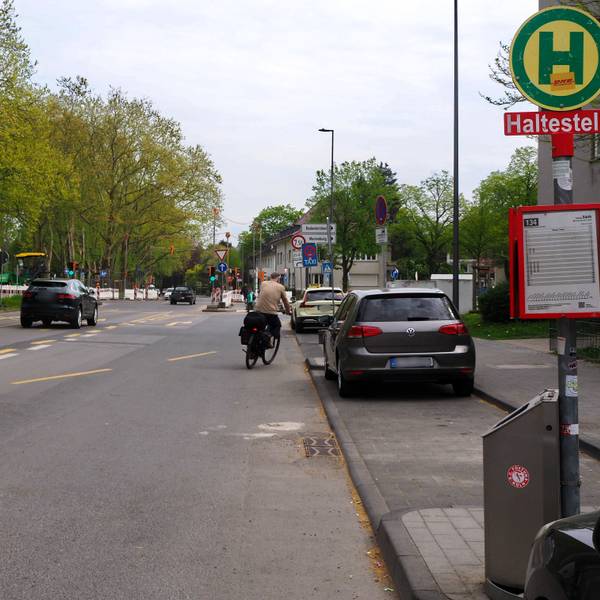 Ein Auto und ein Radfahrer fahren auf dem Raderberggürtel in Marienburg