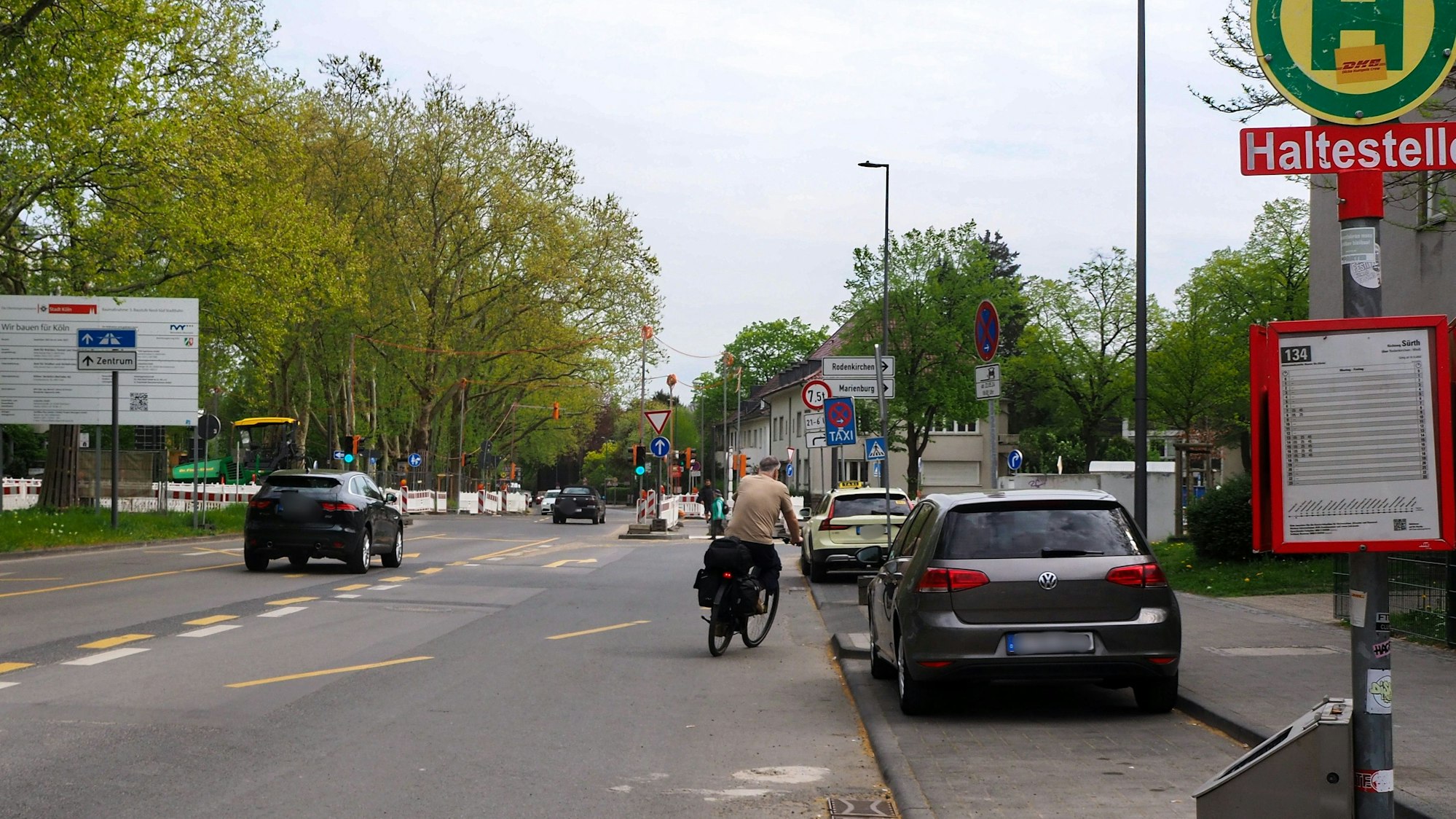 Ein Auto und ein Radfahrer fahren auf dem Raderberggürtel in Marienburg