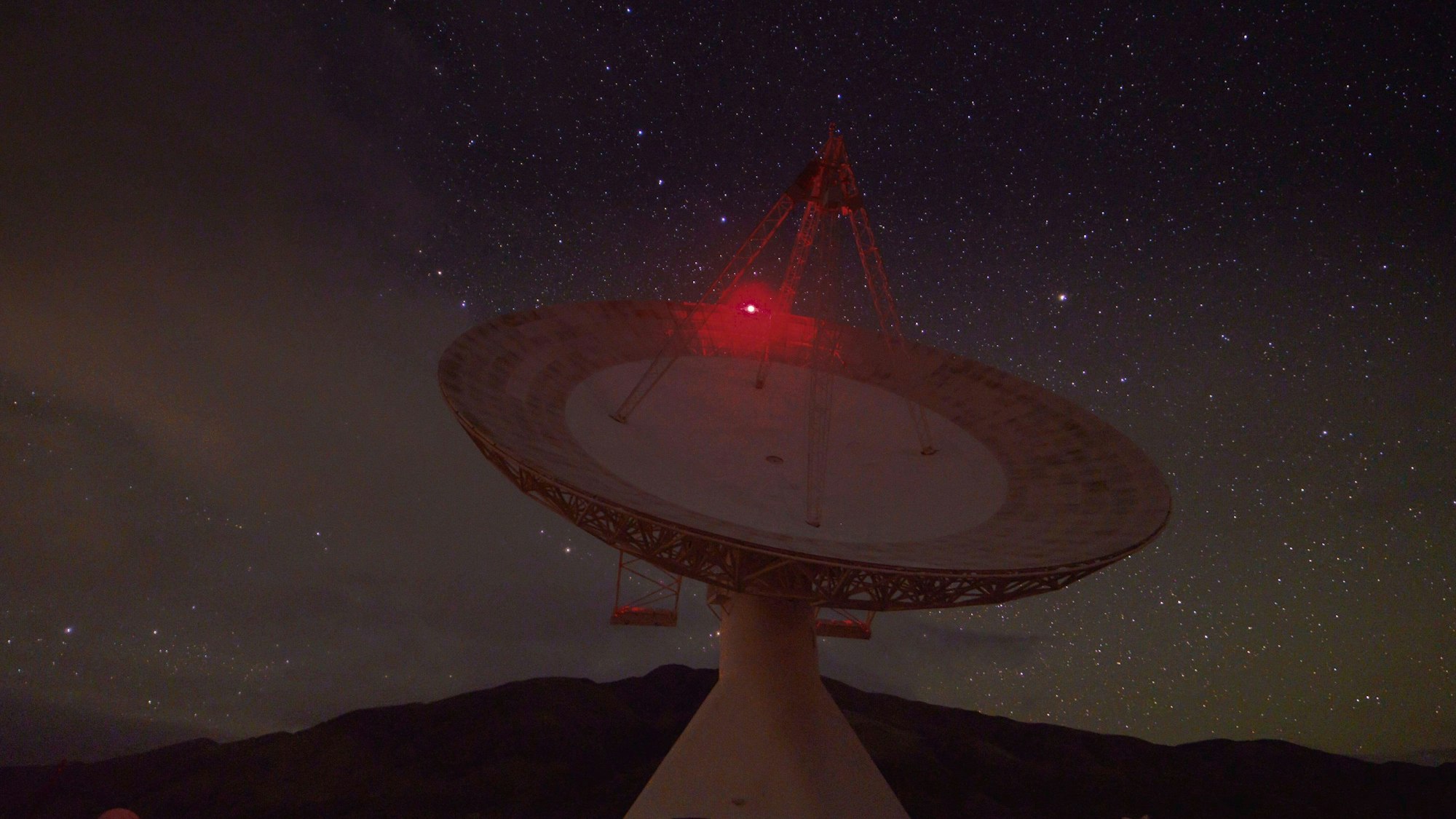 Eine Satelliten-Antenne in der Nacht.