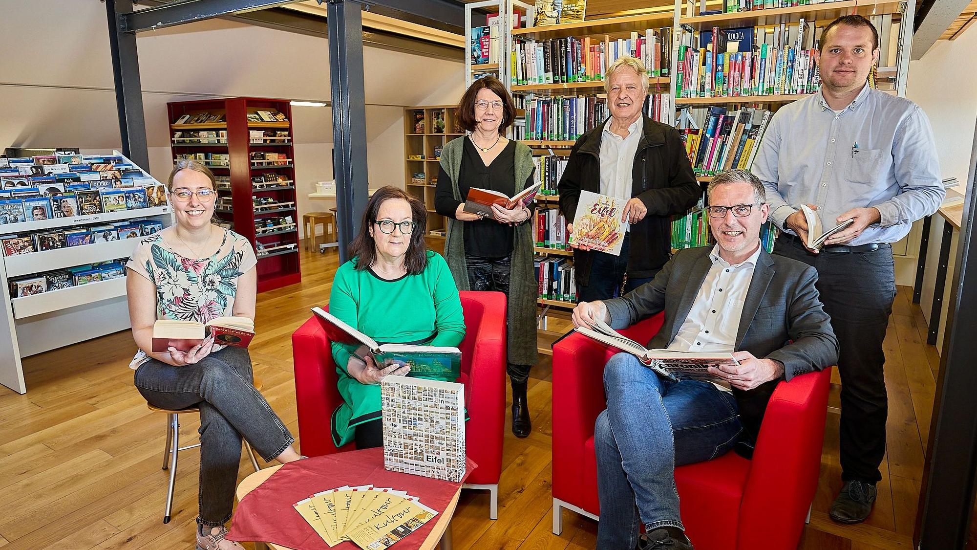 Lea Blindert, Brigitte Wies, Uschi Mießeler, Jochen Starke, Norbert Crump und Alexander Mauel haben sich mit Büchern in der Gemeindebibliothek postiert.