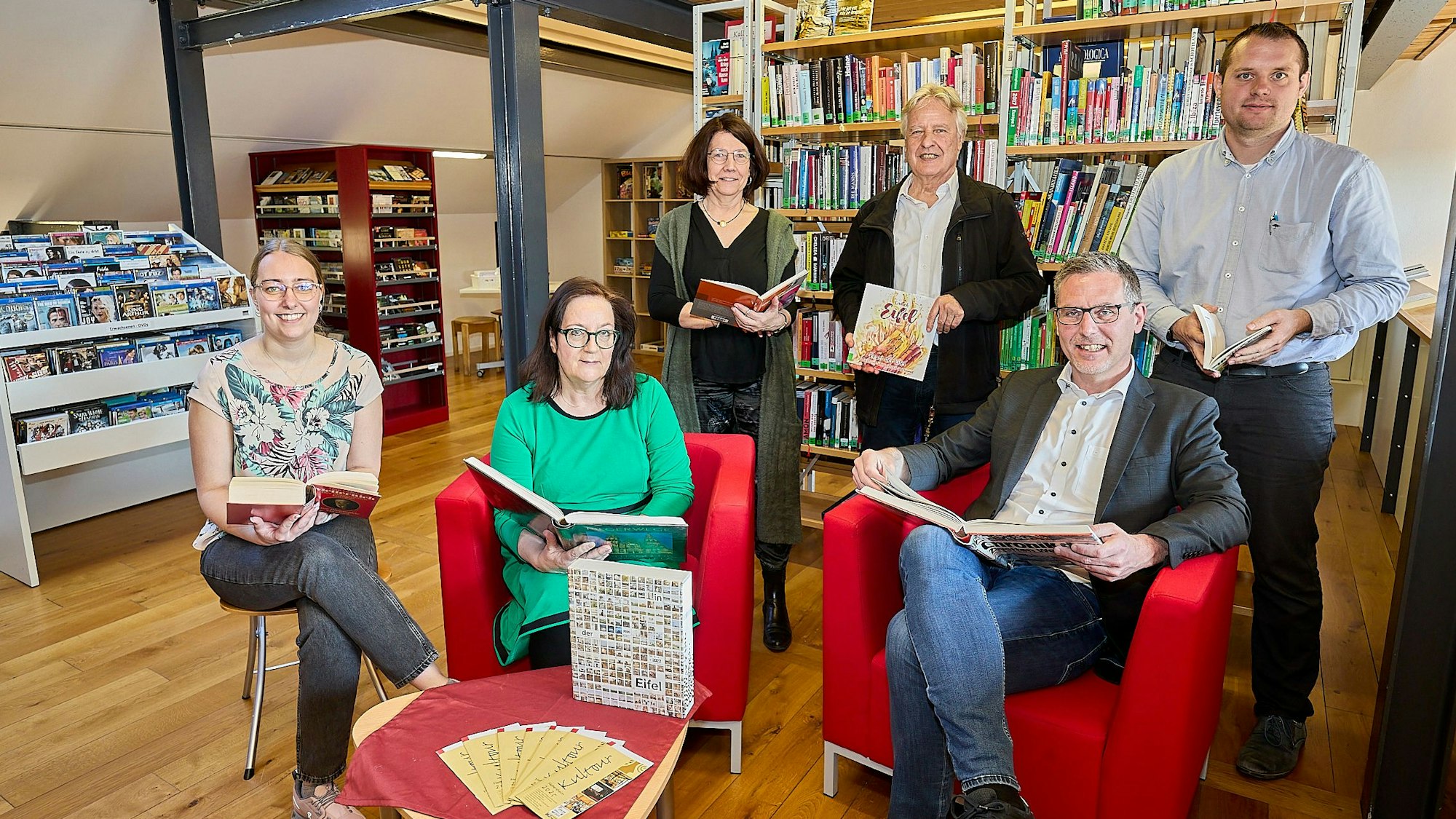 Lea Blindert, Brigitte Wies, Uschi Mießeler, Jochen Starke, Norbert Crump und Alexander Mauel haben sich mit Büchern in der Gemeindebibliothek postiert.