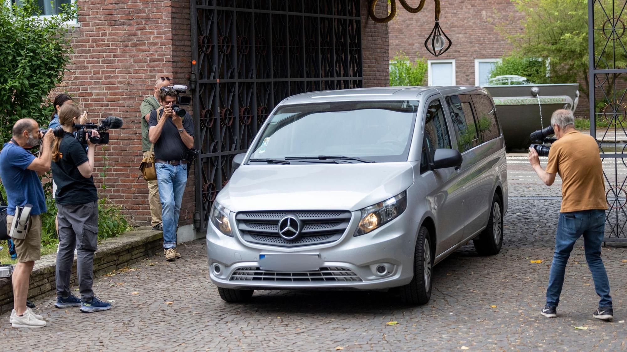 Fotografen und Kameraleute umringen einen Wagen der Kölner Strafverfolgungsbehörden in der Einfahrt zum erzbischöflichen Haus in Köln.