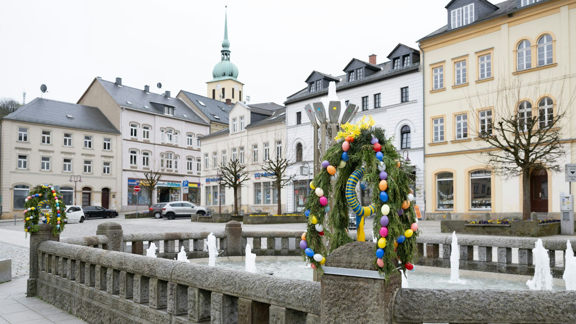 17.04.2025, Sachsen, Sebnitz: Ein mit Osterschmuck verzierter Brunnen auf dem Marktplatz. Mit einer Anzeige im Amtsblatt der Stadt Sebnitz sucht eine Dachdeckerfirma nach Azubis - und macht dabei eine menschenverachtende Einschränkung. Foto: Sebastian Kahnert/dpa +++ dpa-Bildfunk +++
