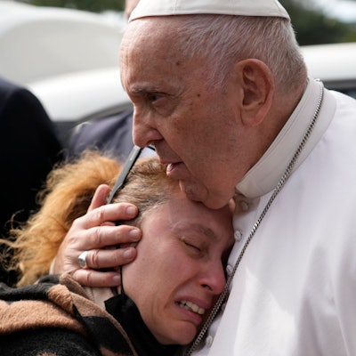 Papst Franziskus tröstet eine weinende Frau.