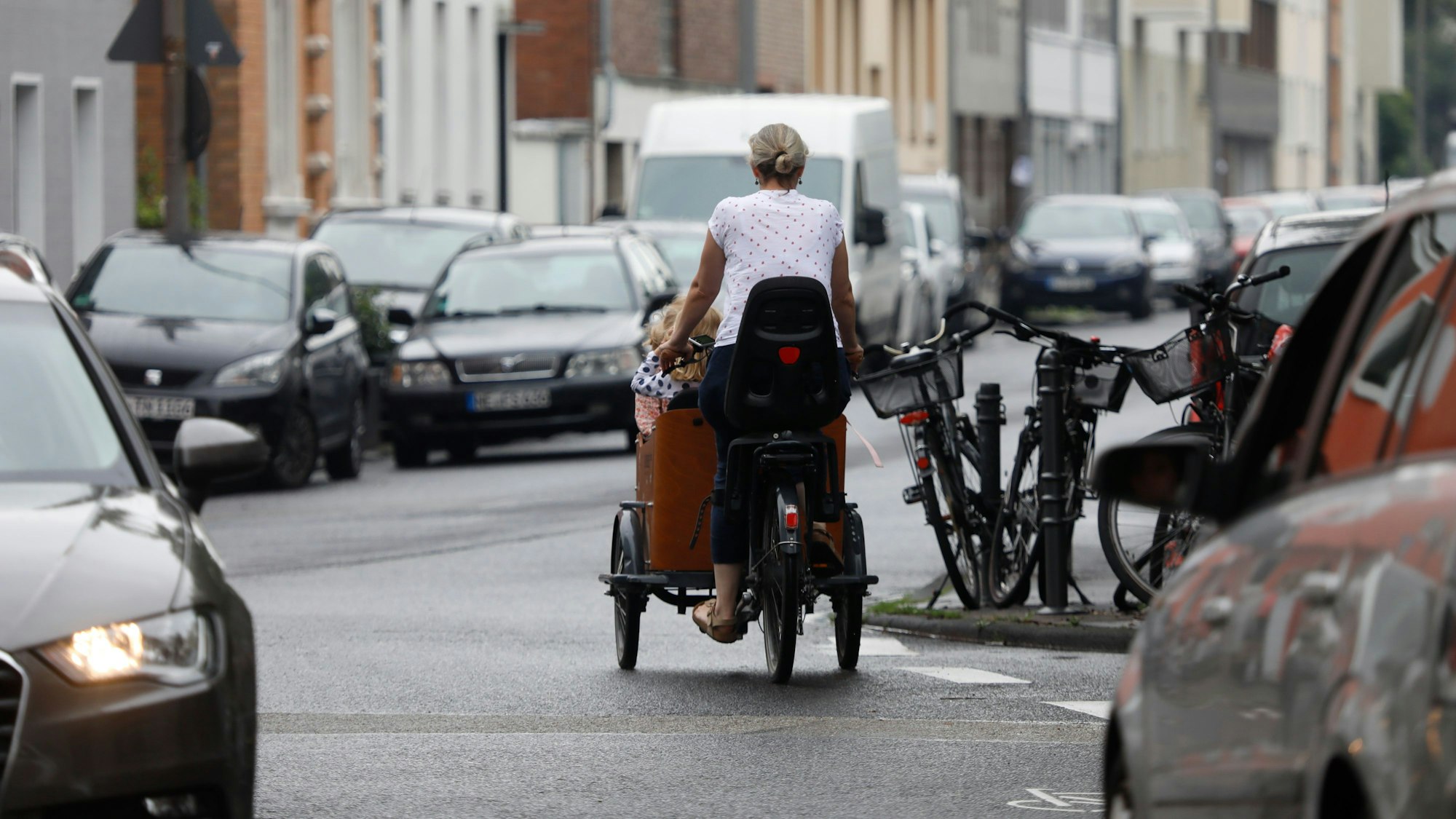 Eine Frau fährt mit ihrem Lastenfahrrad auf der Bachemer Straße entlang.