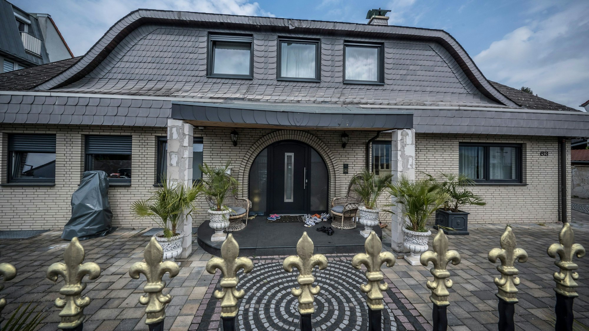 Das Haus von Mohamed El Zein in Leverkusen-Rheindorf. Vor der Tür liegen Turnschuhe, in einer Ecke ein Laubbläser.