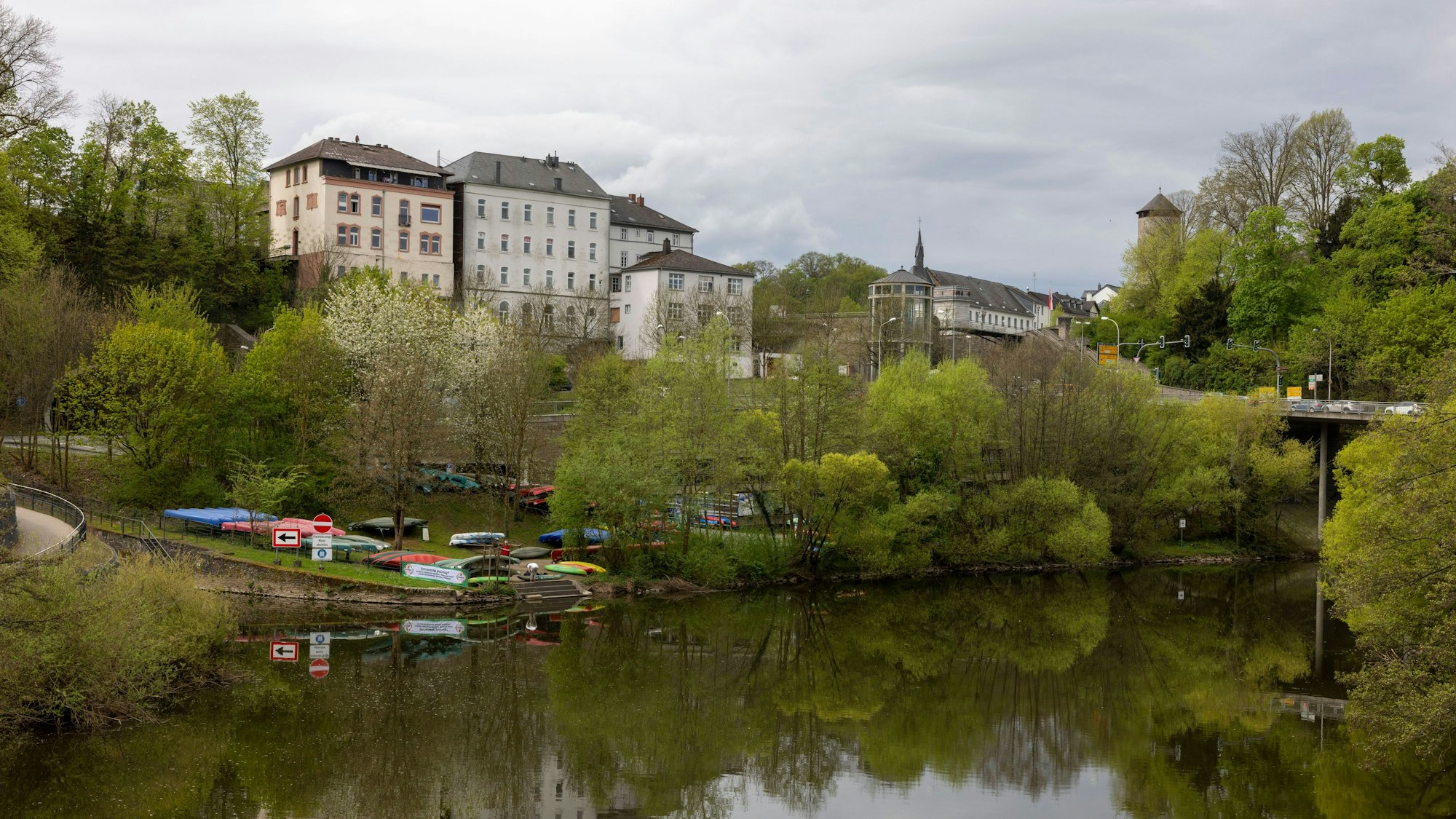 Kanus liegen an der Lahn – im Hintergrund ist Schloss Weilburg zu sehen.