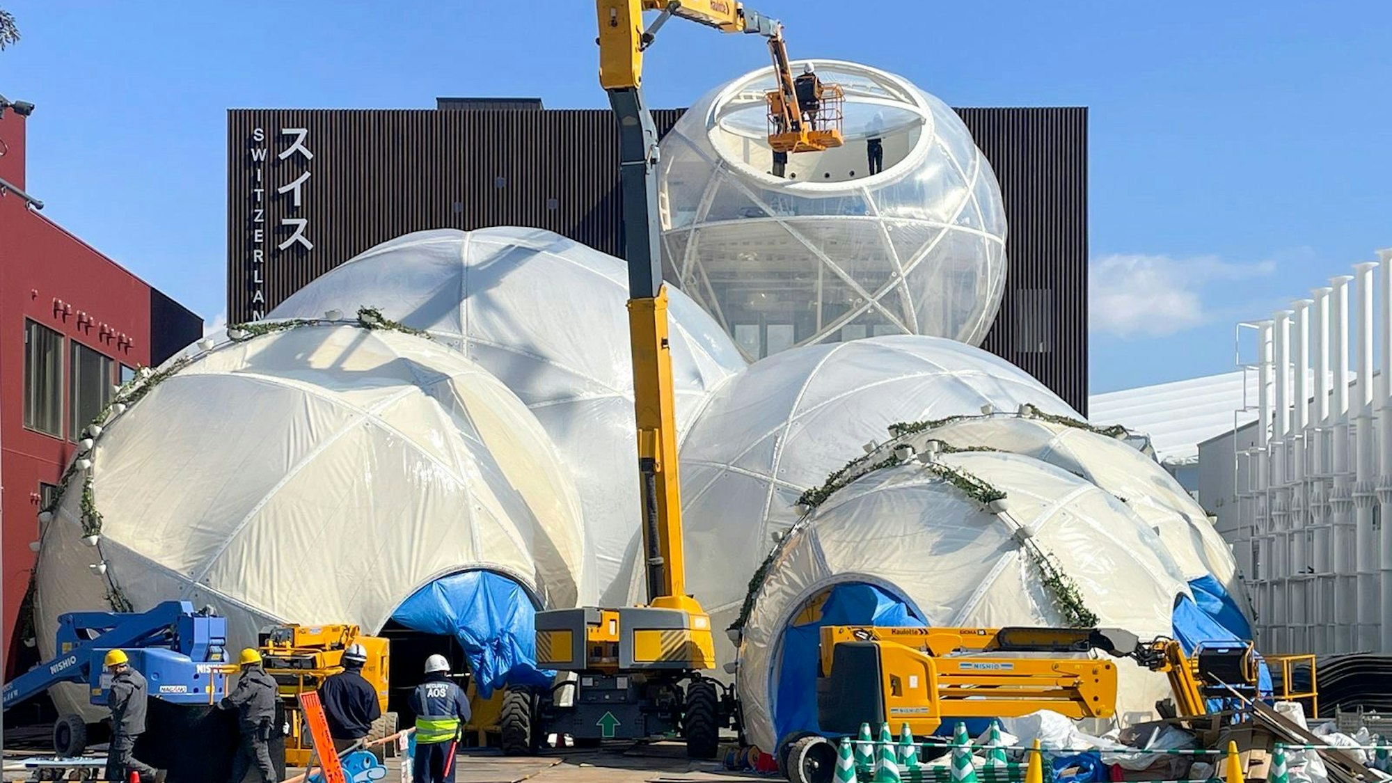 Zu sehen ist ein Pavillon, vor dem ein Kran steht.