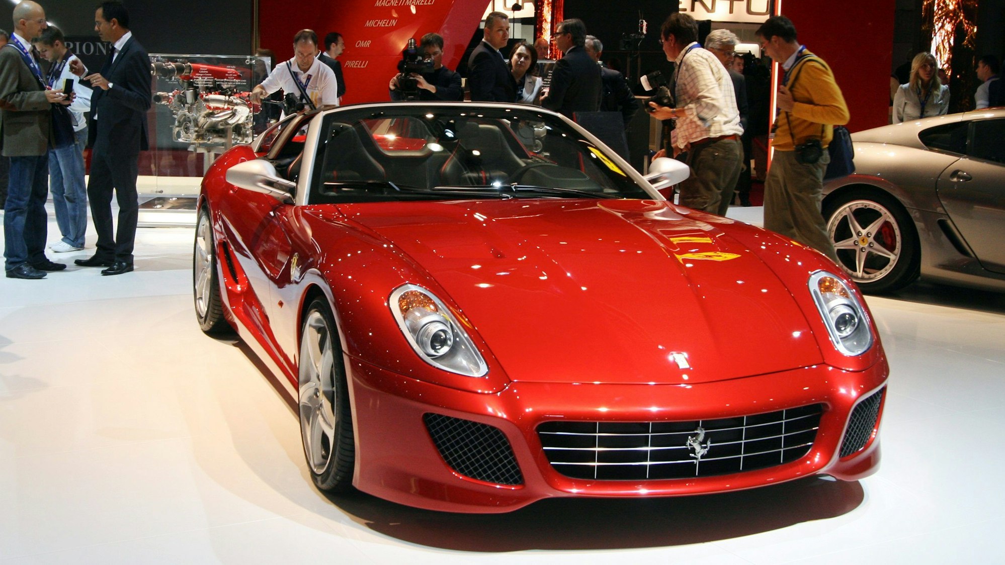 Ein roter Ferrari steht in einer Messehalle.