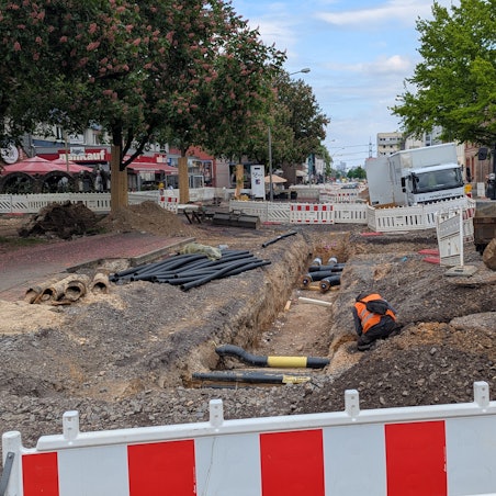 Das Foto zeigt die Verlegung von Fernwärmeleitungen in der Baugrube an der Luxemburger Straße.