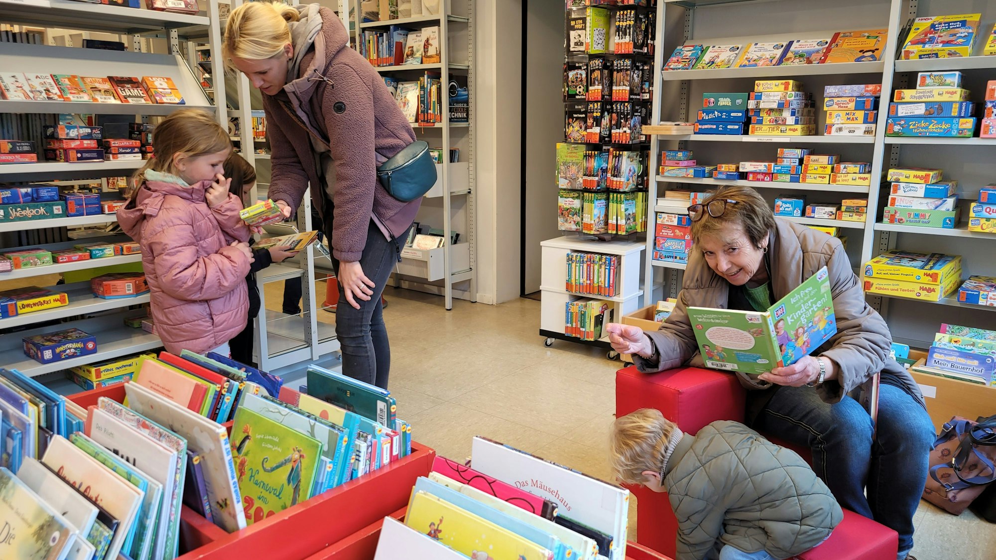 Zwei Frauen und zwei Kindern störbern in Büchern.