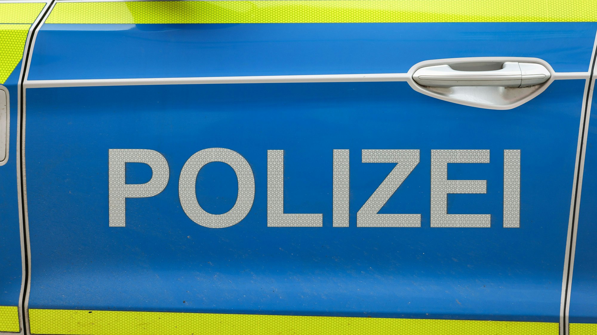 Das Foto zeigt die Tür eines Polizeiautos.