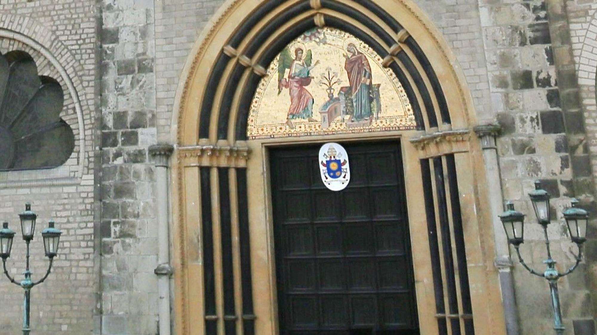 Das Papstwappen von Papst Franziskus hing die letzten zwölf Jahre über dem Hauptportal des Bonner Münster.