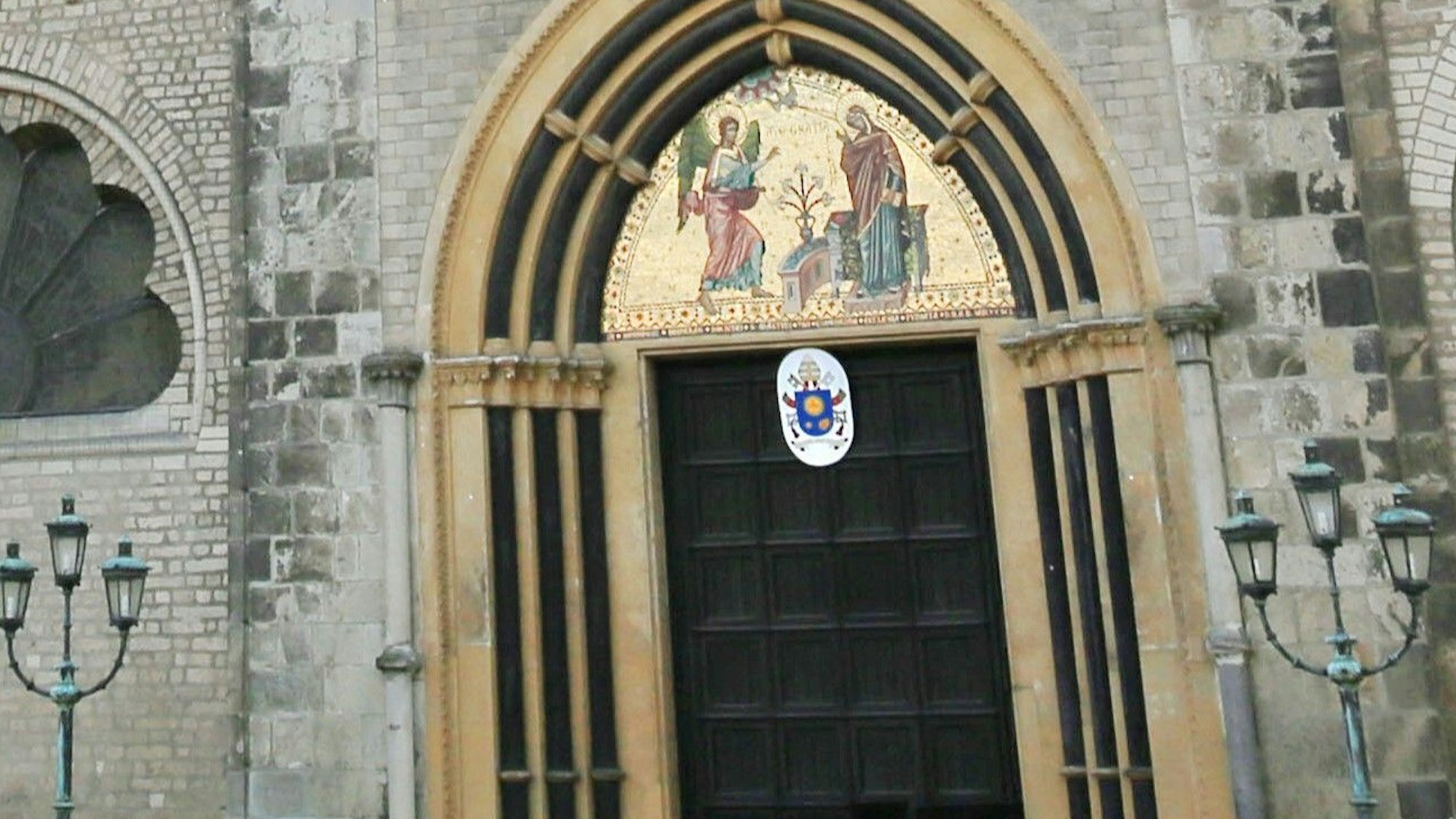 Das Papstwappen von Papst Franziskus hing die letzten zwölf Jahre über dem Hauptportal des Bonner Münster.