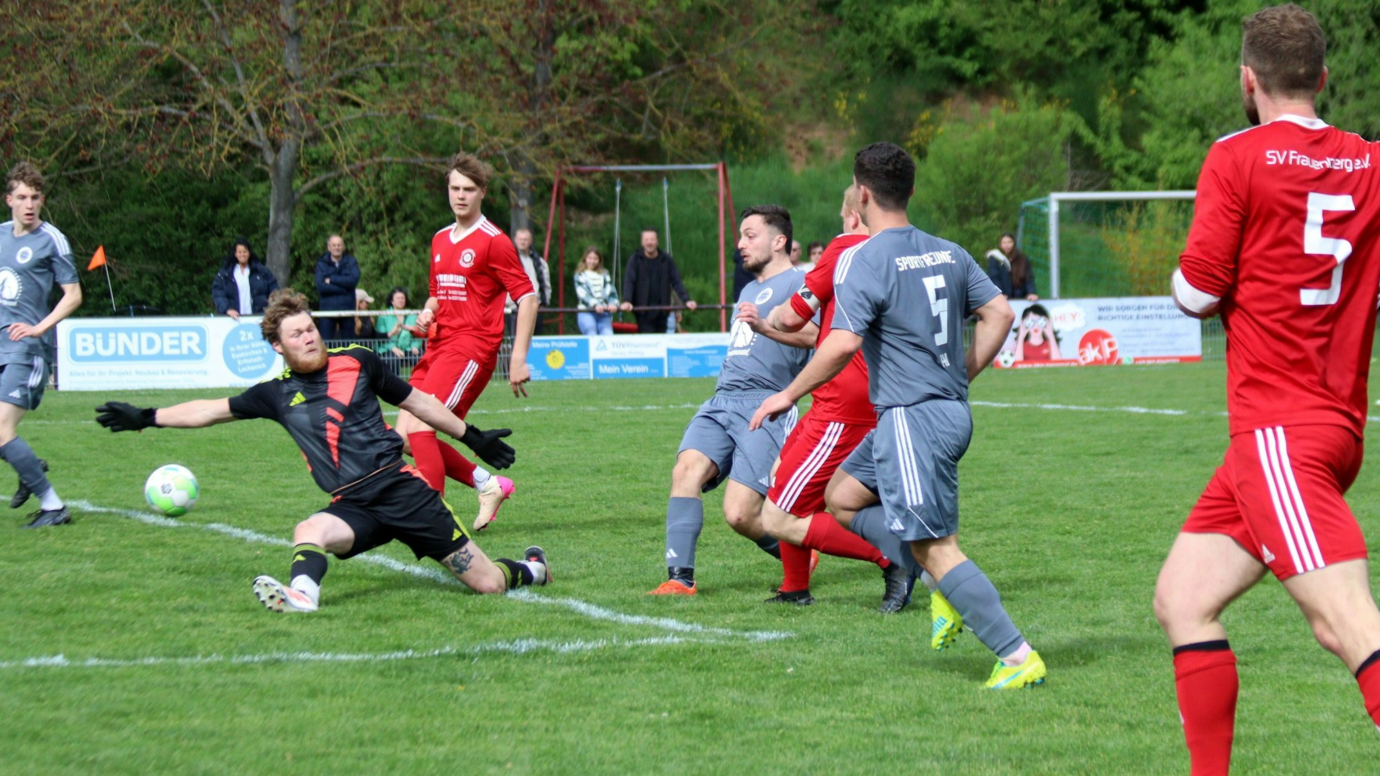 Der Torwart streckt sich vergeblich, der Ball passiert ihn. Auch die Verteidiger kommen zu spät.