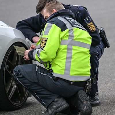 Polizisten kontrollieren ein Auto, das von einer Verkehrskontrolle am sogenannten Car-Freitag herausgezogen wurde. (Symbolbild)