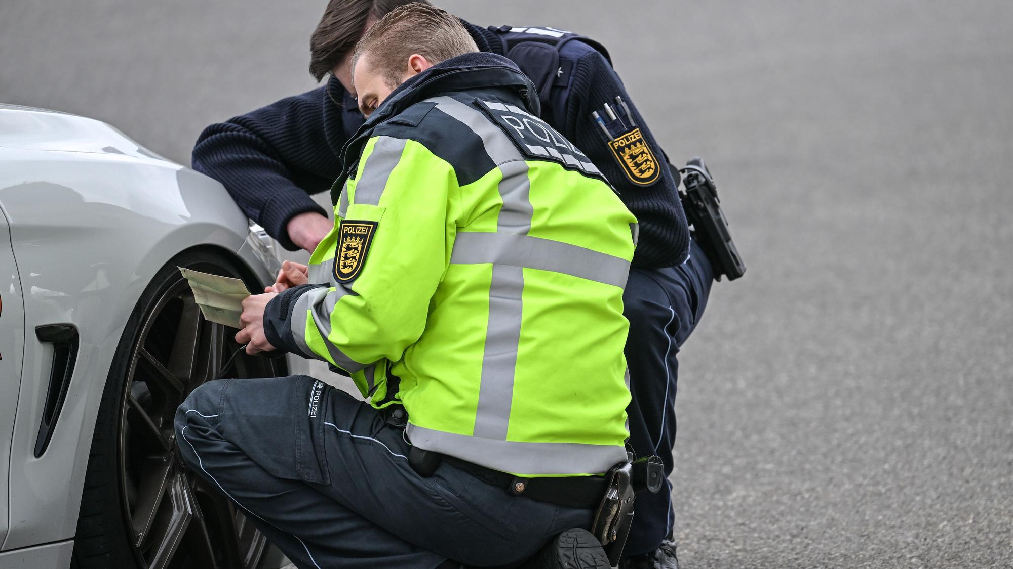 Polizisten kontrollieren ein Auto, das von einer Verkehrskontrolle am sogenannten Car-Freitag herausgezogen wurde. (Symbolbild)
