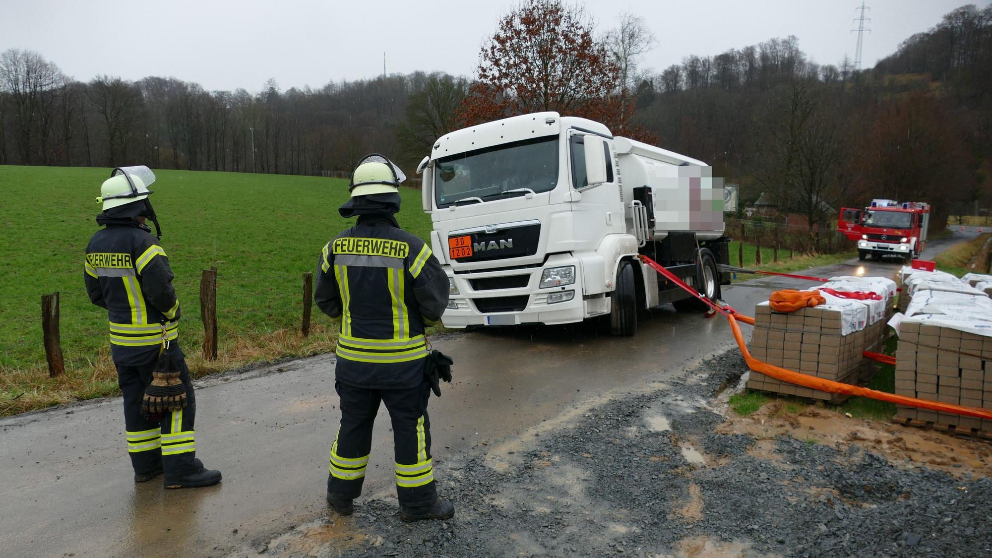 Mit Pflaster für eine nahe Baustelle hinderte die Feuerwehr den Tanklaster gegen das Abrutschen in den nahen Siefen.