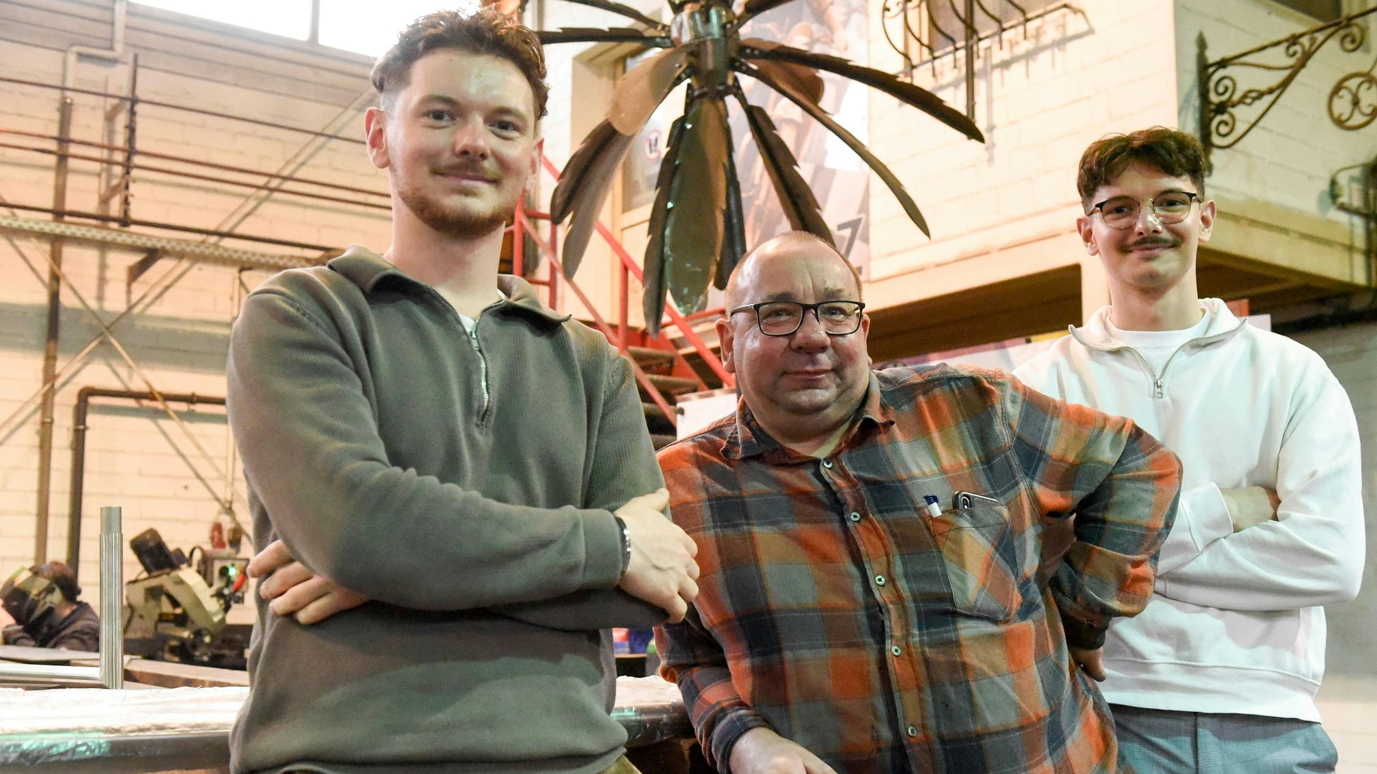 Drei Männer stehen nebeneinander und lächeln.