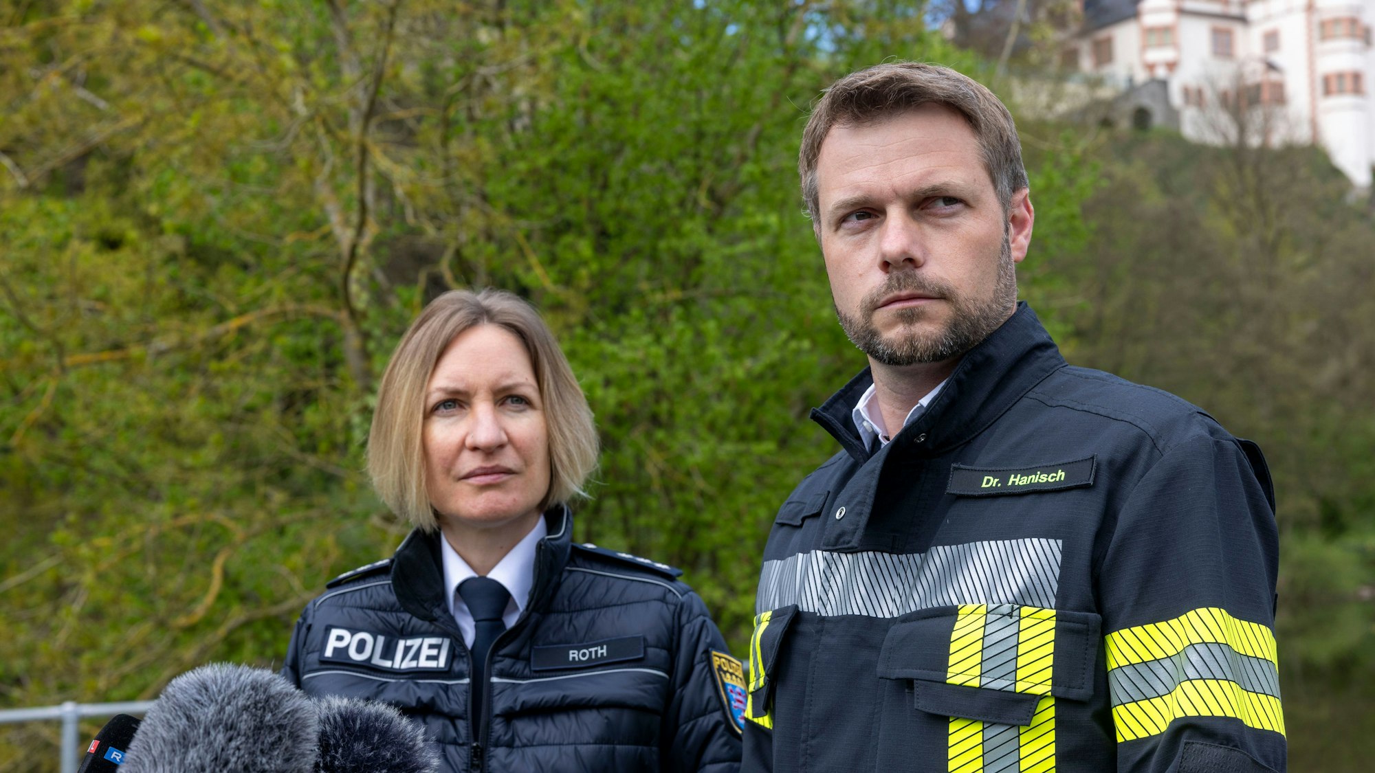 Johannes Hanisch (CDU, r), Bürgermeister von Weilburg, und Ilka Roth, Sprecherin der Polizei, geben eine Erklärung zum Fund der Kinderleiche in der Lahn ab.