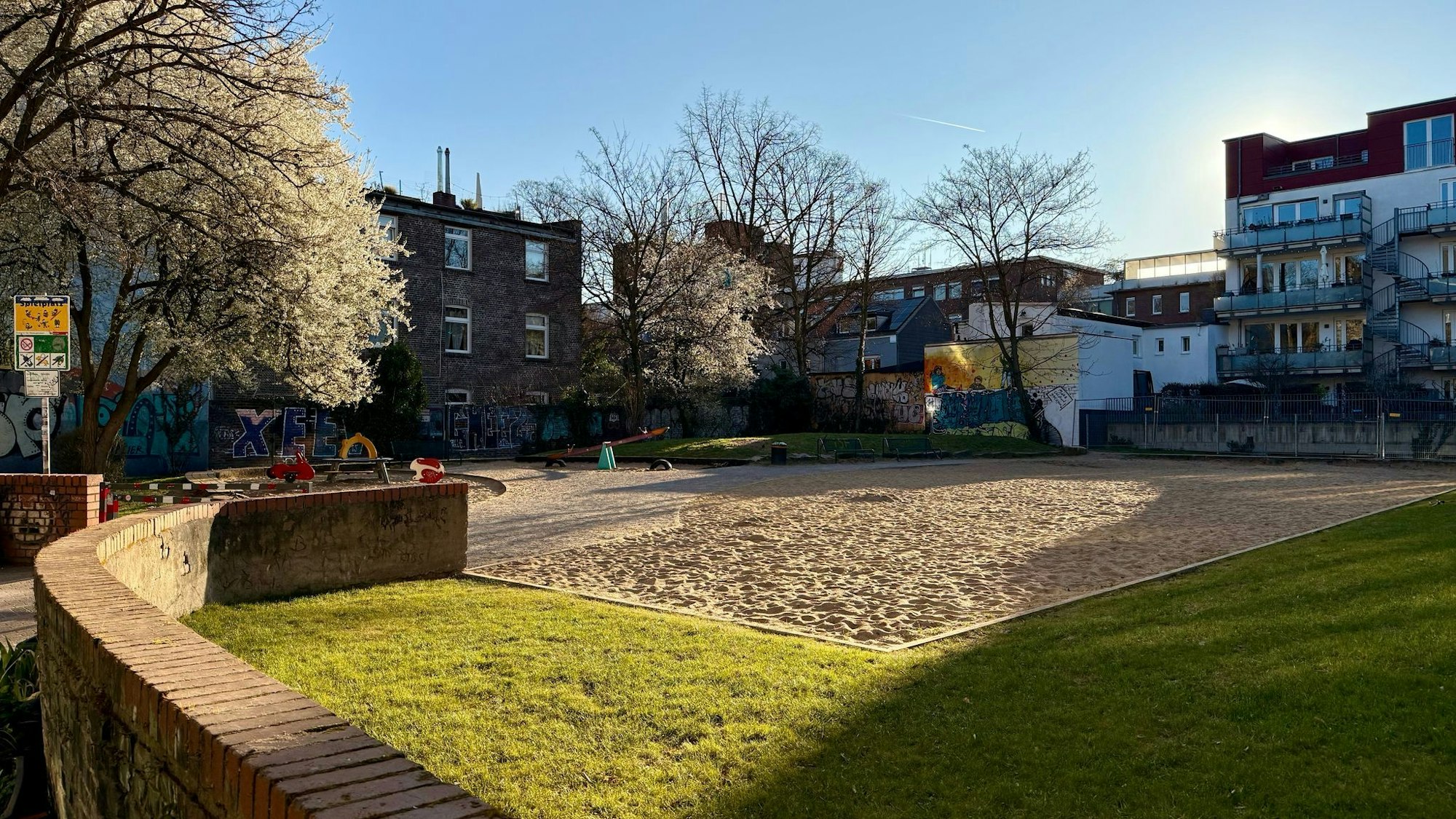 Ein riesiger leerer Sandkasten macht die größte Fläche eines Spielplatzes aus.