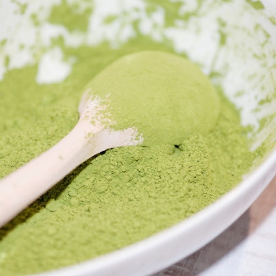 Matcha-Pulver in einer Schale mit einem Löffel.