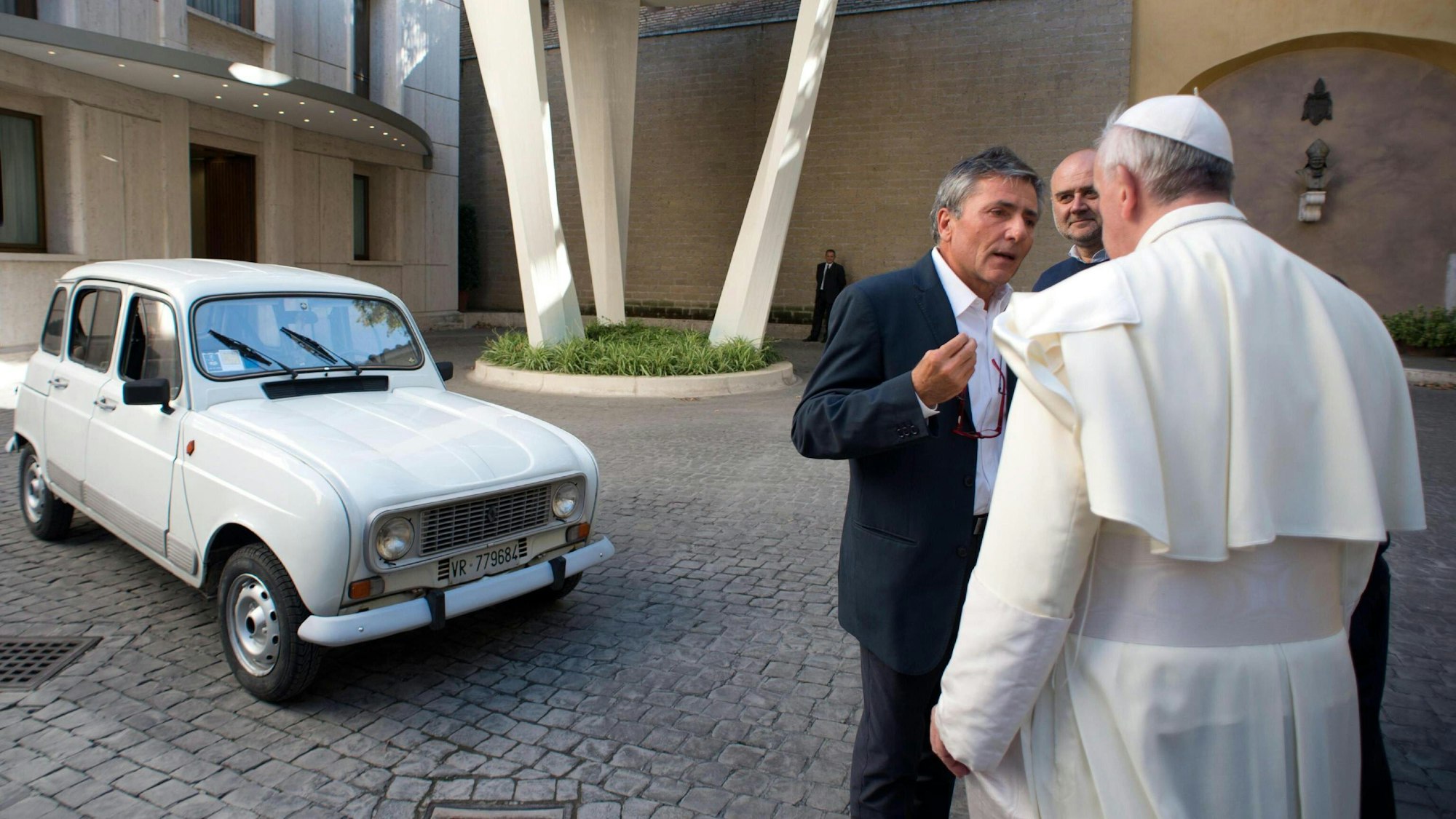 Papst Franziskus (r) mit seinem privat genutzten Renault R4 auf dem Hof der Vatikanstadt.