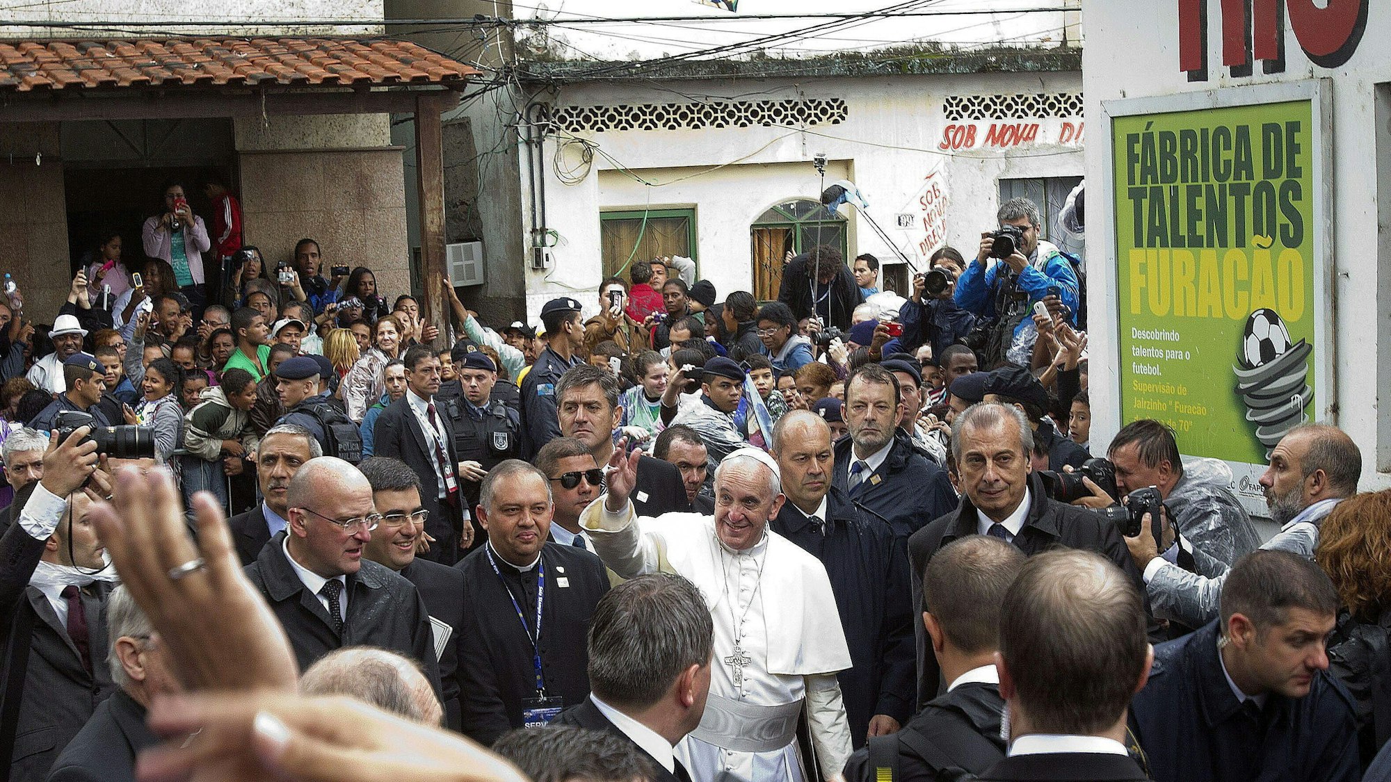 Papst Franziskus (m) grüßt die Menge bei seinem Besuch in der Favela Varginha in Rio de Janeiro in Brasilien.