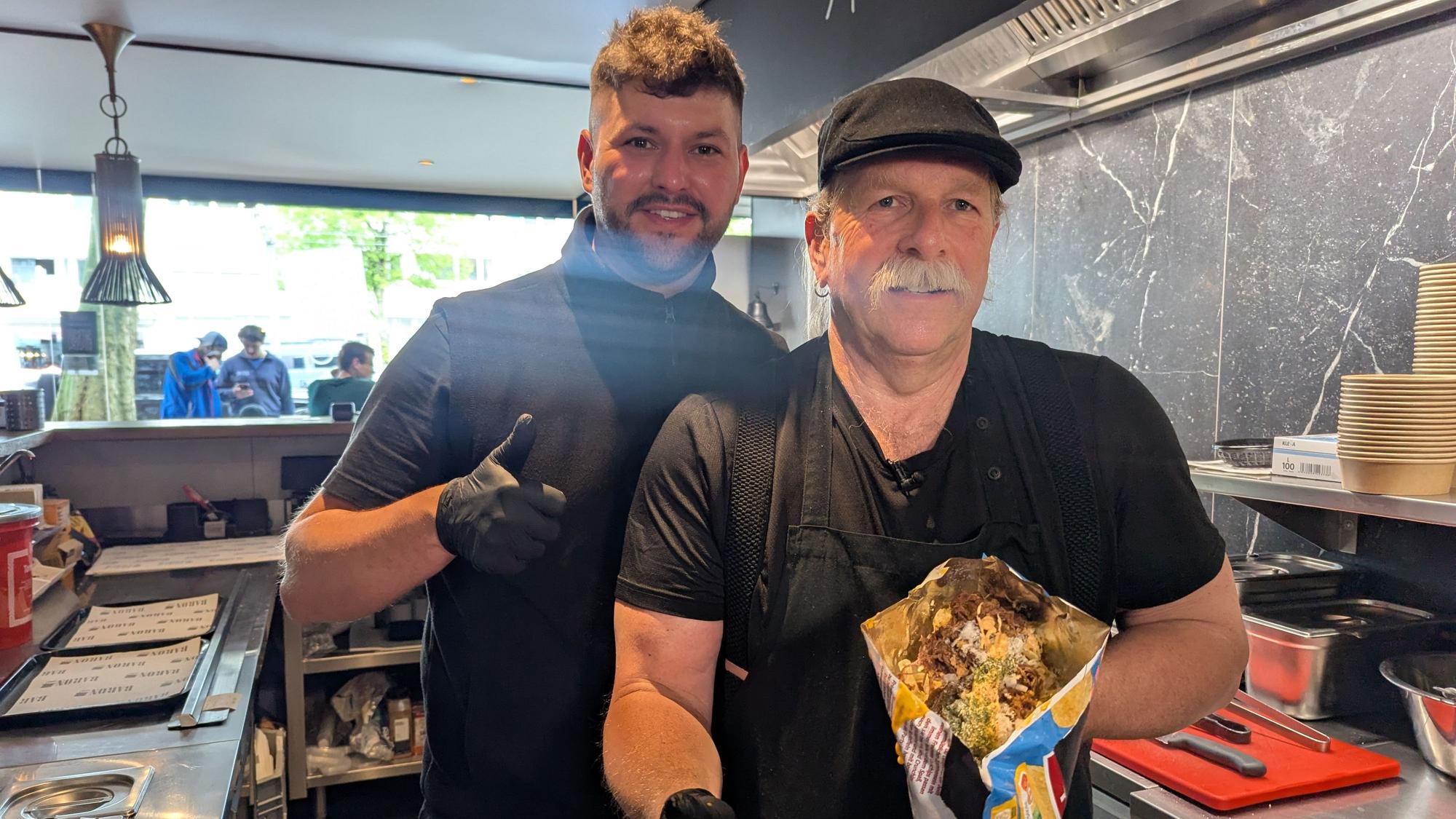 Gründer Alexander Schebalkin (l) mit Mitarbeiter Sui, der eine Portion der LoadedChips im Kölner Baron-Imbisskult vorzeigt.