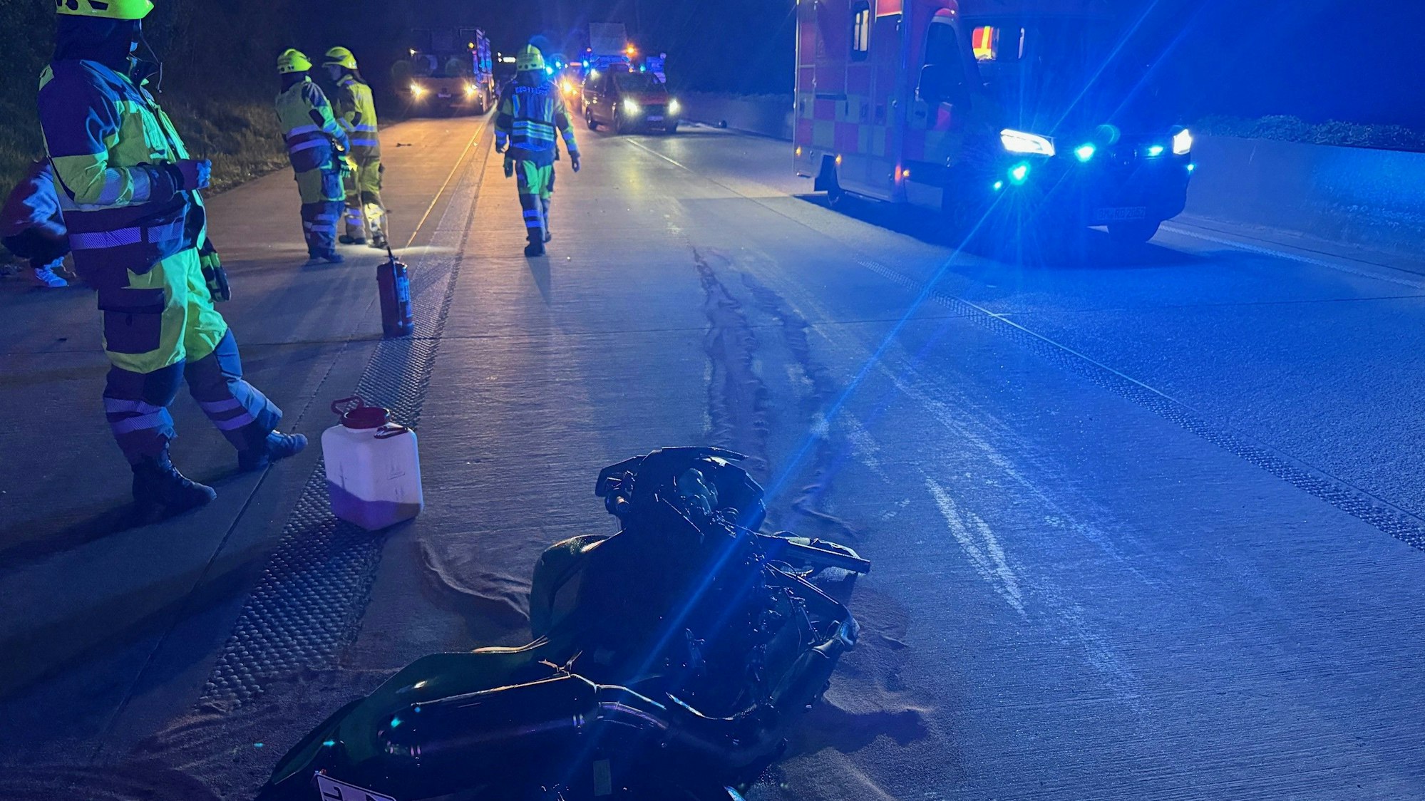 Das Bild zeigt Einsatzkräfte der Feuerwehr neben einem beschädigten Motorrad.