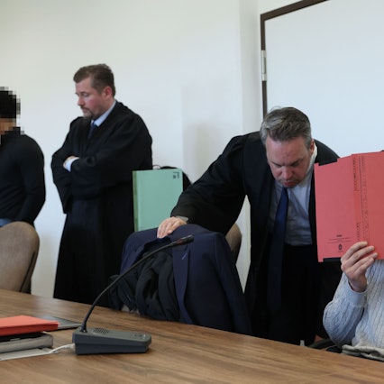 Die drei Angeklagten mit ihren Verteidigern beim Prozessauftakt im Kölner Landgericht