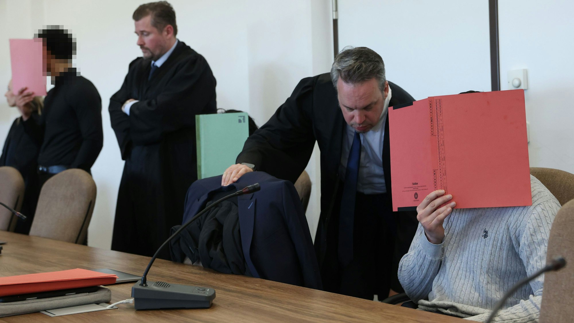 Die drei Angeklagten mit ihren Verteidigern beim Prozessauftakt im Kölner Landgericht